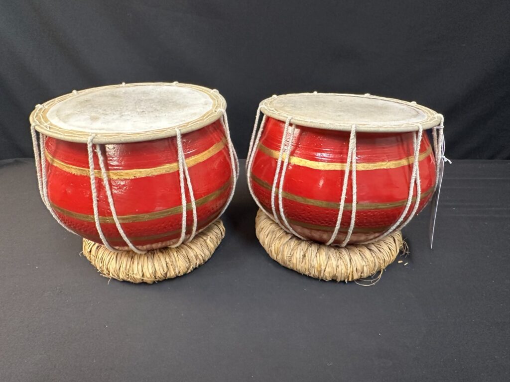 9" diameter pair of hand red and painted hand drums, low and high, w/ cushions.